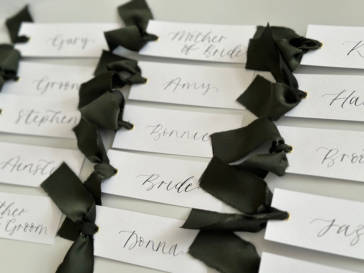 White Forest Satin Wedding Place Cards with Ribbon | Dark Green Calligraphy Place Cards