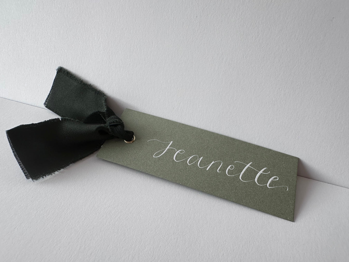 dark green wedding place card, rustic wedding decor, elegant escort cards, customizable place settings, eco-friendly wedding details, garden wedding theme, personalized card holders, handwritten calligraphy, vintage wedding styling, sustainable wedding accessories