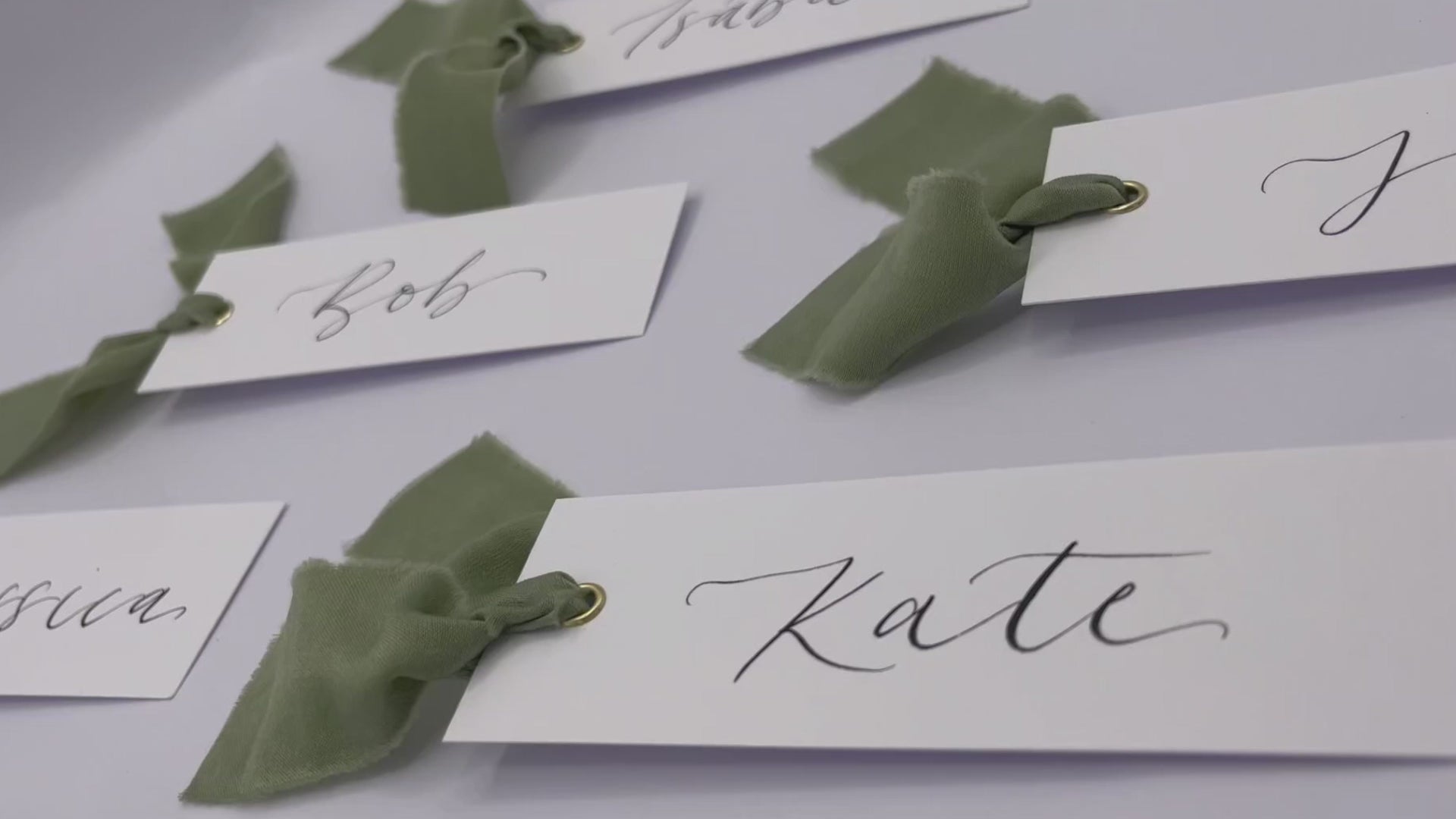 Load video: Calligraphy place cards with eucalyptus dark green ribbon and gold eyelets, wedding place card, wedding place name