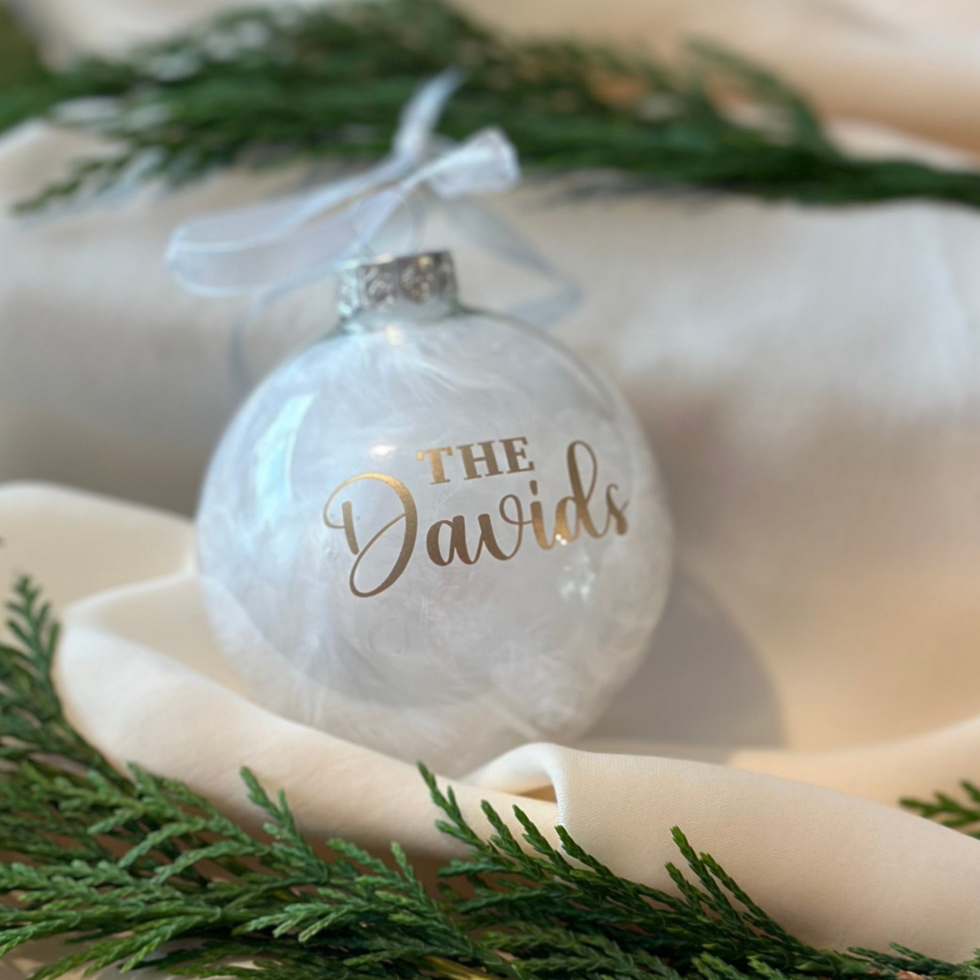 Decorative ornament with 'The Davids' text on a table with greenery
