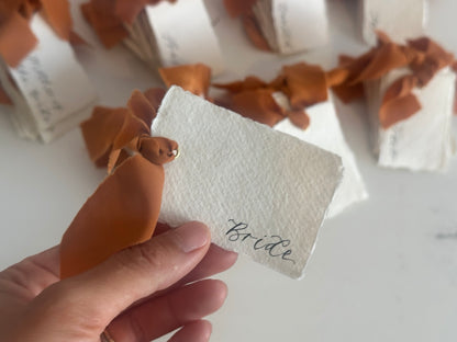 Handwritten handmade paper place cards with ochre ribbon