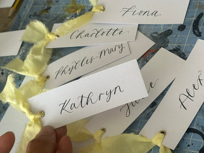 BUTTER Ribbon Calligraphy Place Name Card | White Calligraphy Wedding Place Name Card | Gold or Silver Eyelet