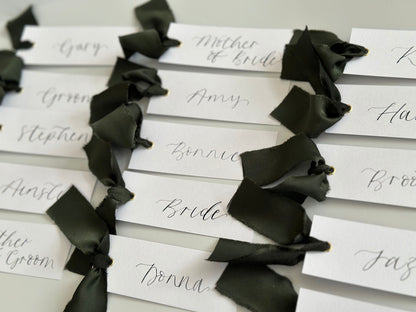 White Forest Satin Wedding Place Cards with Ribbon | Dark Green Calligraphy Place Cards