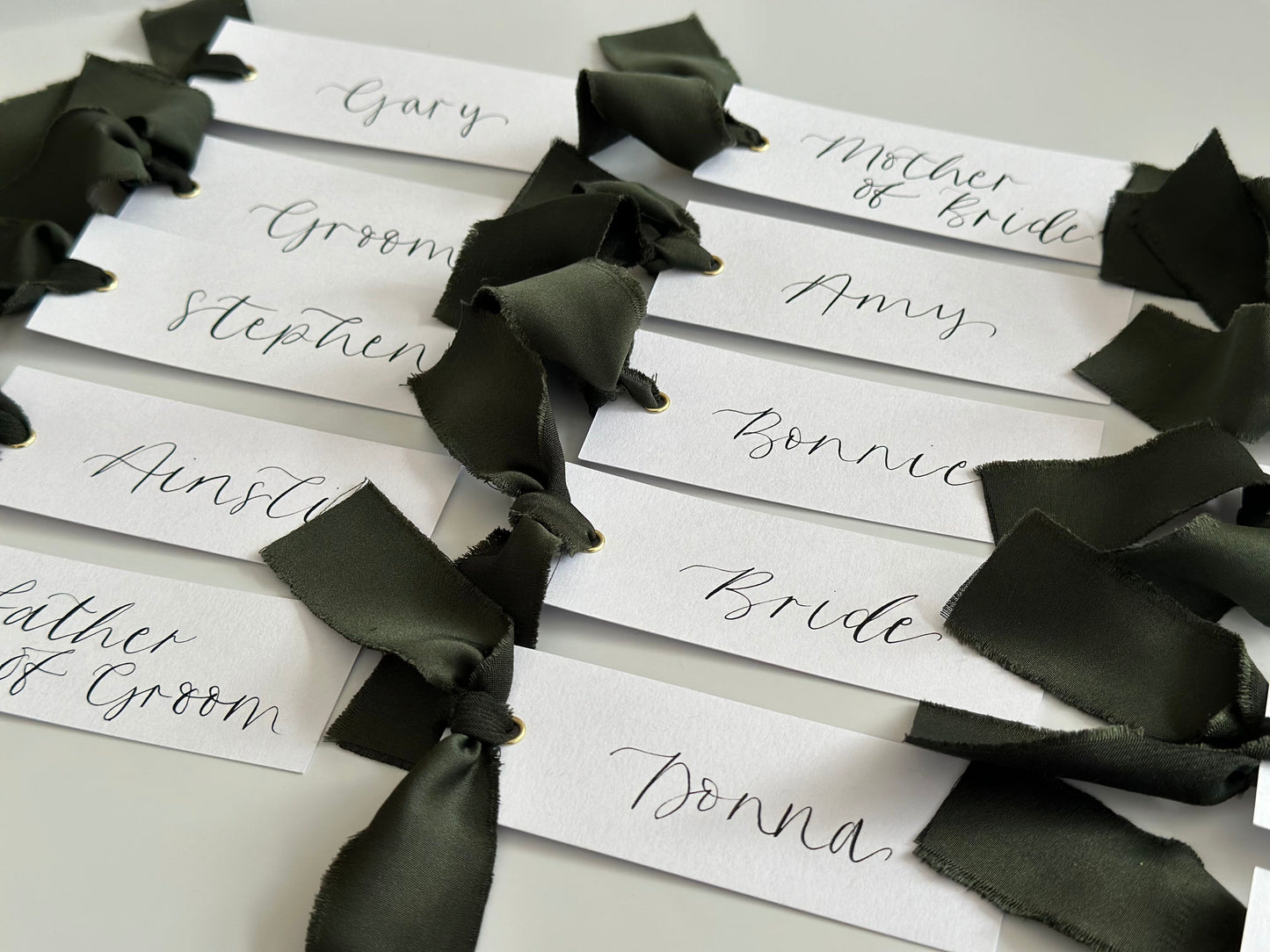 White Forest Satin Wedding Place Cards with Ribbon | Dark Green Calligraphy Place Cards