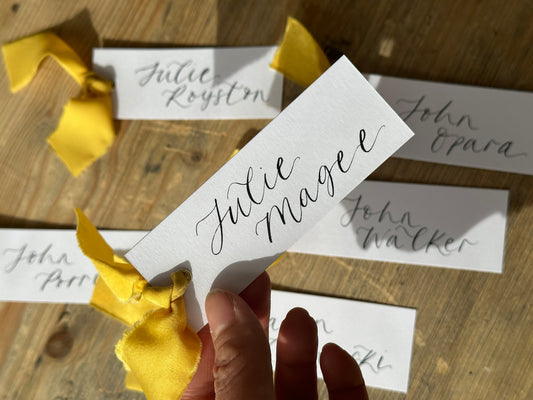 place cards with lemon yellow ribbon and handwritten calligraphy