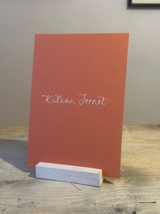 Colourful ochre wedding table name sign with white handwritten calligraphy, no ribbon
