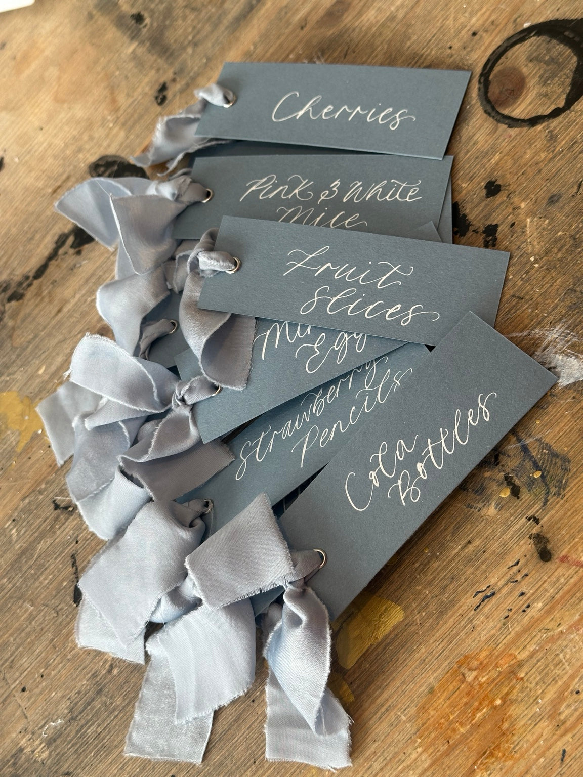 Wedding sweet cart labels on dusky blue card with white calligraphy