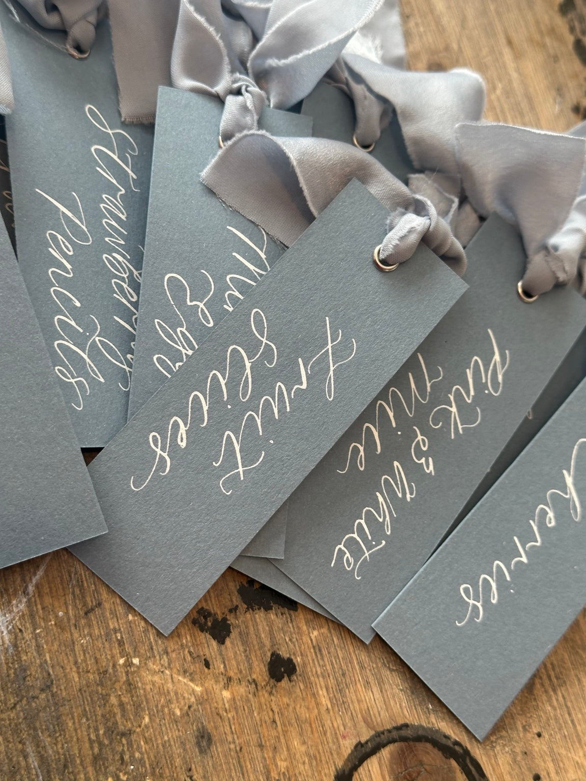 Luxury wedding sweet buffet labels handwritten in white ink on dusky blue card