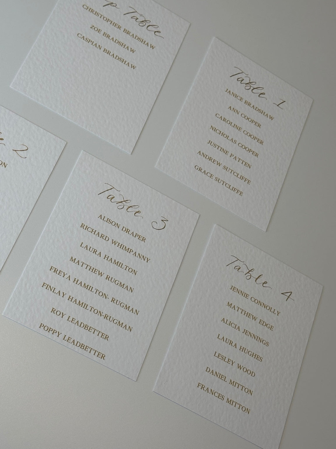 Four personalised wedding table plan cards arranged together