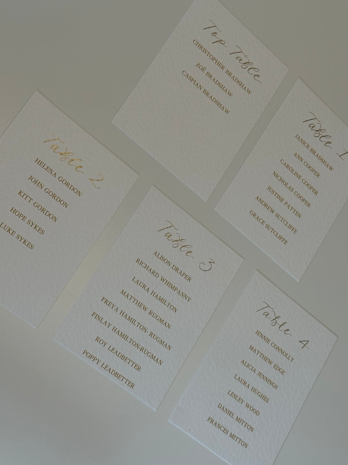 Overhead arrangement of personalised wedding table plan cards