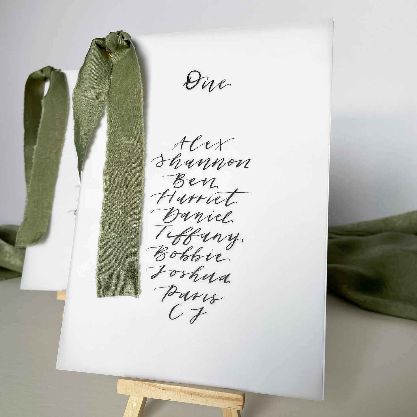 vellum Table plan card with chiffon ribbon , modern calligraphy, calligraphy table plan, vellum table plan, handwritten table plan card, modern table plan, traditional table plan, modern wedding decor, chiffon table plan, ribbon table plan, eucalyptus, sage, green, forest green, 